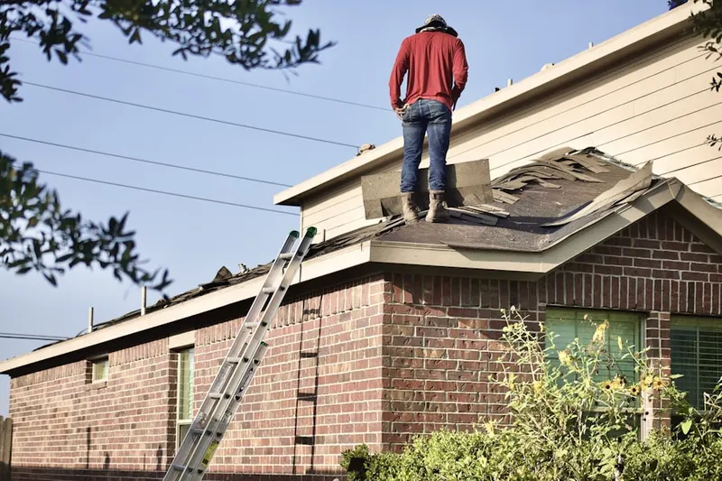 Professional roofer working on a residential roof in Huntley Hills